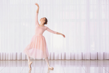 Beautiful young ballerina in dance studio
