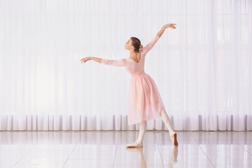 Fototapeta na wymiar Beautiful young ballerina in dance studio