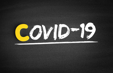 Covid-19 (Coronavirus) text on blackboard, medical concept background