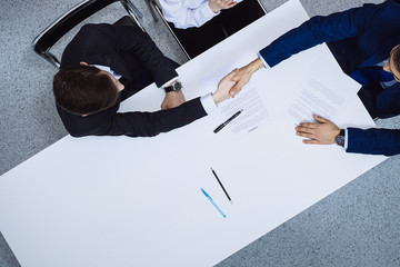 Group of business people and lawyer discussing contract papers sitting at the table, view from...