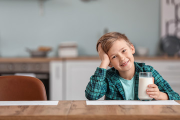 Little boy drinking milk in kitchen