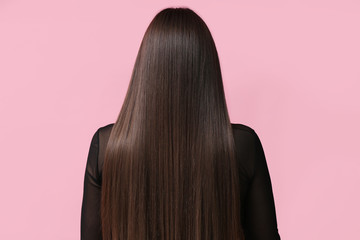 Young woman with beautiful straight hair on color background