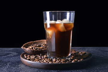 Glass of tasty iced coffee on dark background