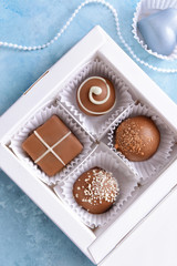 Box with delicious candies on color background