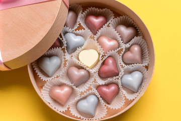 Box with delicious candies on color background