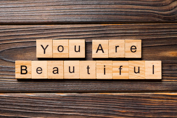 You are beautiful word written on wood block. You are beautiful text on wooden table for your desing, Top view concept