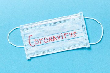 Blue novel disease background made of protective medical masks. Top view of coronavirus word. Global epidemic concept