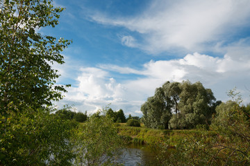 Obraz premium cloudy clouds over the river in summer