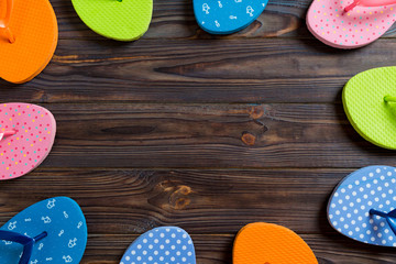 a lot of flip flop colored sandals, summer vacation on wooden background, copy space top view