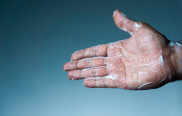 Coronavirus becomes ineffective with soap. the man's soapy hand written "covid-19"