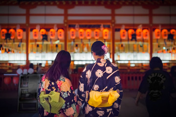 Young women dressed in kimono visiting Fushimi Inari shrine during Motomiya festival in Kyoto, Japan