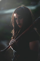 chica vestida de negro con el bate de The Walking Dead, en un descampado y diferentes poses para...