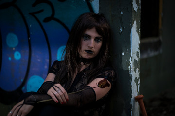 chica vestida de negro con el bate de The Walking Dead, en un descampado y diferentes poses para...