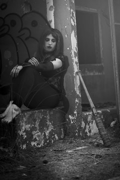 chica vestida de negro con el bate de The Walking Dead, en un descampado y diferentes poses para transmitir diferentes sensaciones y/o emociones.