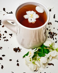 Tea cup and dried and fresh fragrant Jasmine flowers
