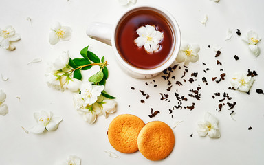 Tea cup with dried and fresh Jasmine flower and biscuits