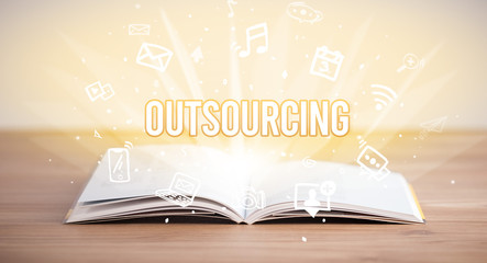 Opeen book with OUTSOURCING inscription, business concept