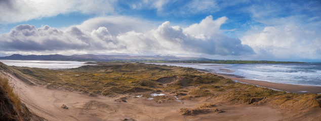 Panorama image. View from dunes on Strandhill beach in county Sligo, Sunny day, Beautiful sky, mountains in the background,