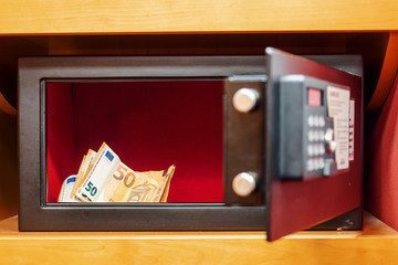 Small safe box with electronic code, door is open, Euro banknotes inside safe. Concept security. Selective focus.