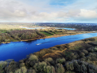 Aerial view on River Corrib, county Galway, Small fishing boat on water, blue cloudy sky. Warm sunny day.