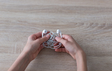 in the hands of a guy tangled wired headphones