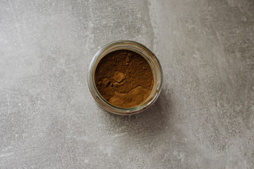 Cocoa powder or carob in a glass jar, top view. Superfood concept