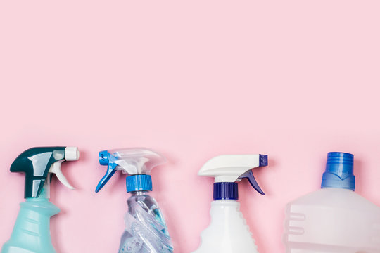 Productos de limpieza, Botellas de detergente pulverizador sobre fondo liso rosa aislado. Vista superior. Copy space