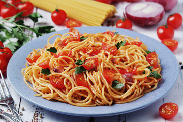A plate with spaghetti with tomatoes