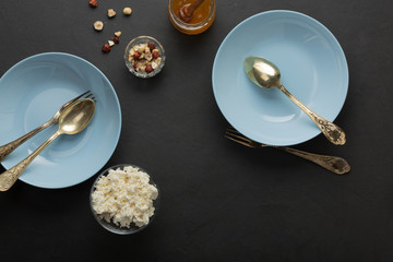 Blue breakfast dishes on dark concrete. Nuts, honey, fruits. Healthy Cooking