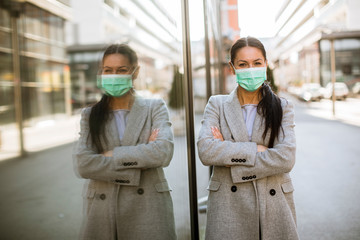 Pretty young woman with protective facial mask on the street