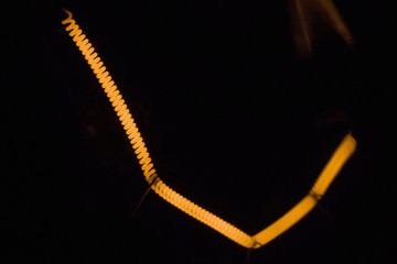 Incandescent lamp close-up. The lamp came on . The light bulb hangs in a dark room. Energy concept. Ecology, energy collapse