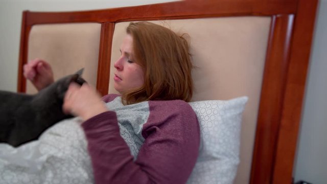 Young girl and cat sick in bed 4k