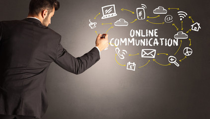businessman drawing social media icons with ONLINE COMMUNICATION inscription, new media concept