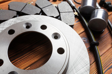 brake parts on wooden background  brake pads, disc, brake hose, guides, cylinders- Image