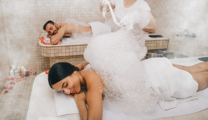 Hammam clients enjoying a foam massage in a Turkish bath. Procedures in oriental bath improves skin...