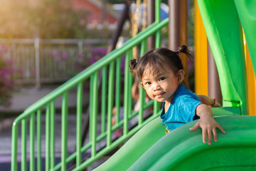 Fototapeta na wymiar Portrait image of 2-3 yeas old baby. Happy Asian child girl smiling and laughing. She playing with slider bar toy at the playground. Learning and active of kids concept.