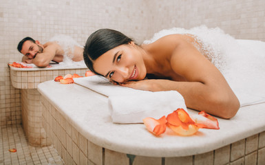Beautiful woman and her boyfriend enjoy a Turkish bath. Hot steam warmed the bodies of a man and a woman in a hammam - obrazy, fototapety, plakaty