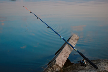 A fishing line is fishing near a blue lake