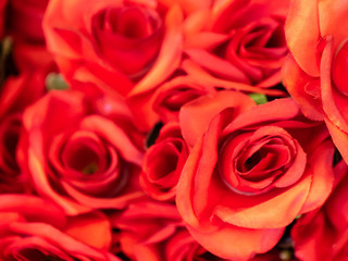 Close up imitation or artificial red rose flower background. Selective focus.