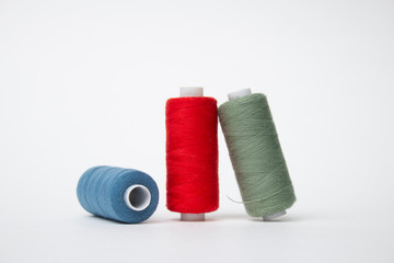 Group of Three whole haberdashery item colorful thread spools isolated on white background. Coloured threads. Colorful bobbin thread. 