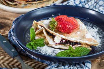 Polish pancakes with jam, cheese and strawberries.