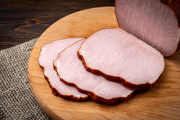 Smoked pork meat on dark wooden background.
