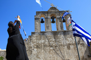 Moni, Naxos / Greece - August 23, 2014: A priest near The church of Panagia Drossiani nea Moni...