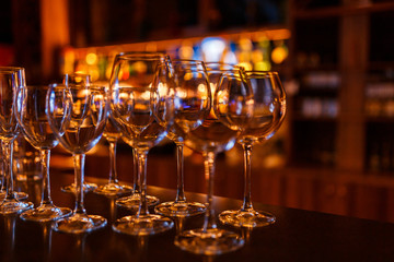 Many wine glasses on the bar with brilliance and light