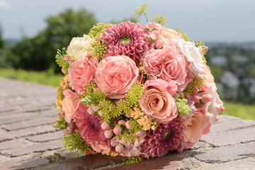Rosa Brautstrauß auf einer Mauer