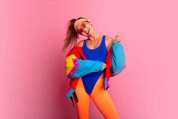 Back in time 90s 80s. Stylish girl in retro jacket and vintage aerobic body jump suit dancing,...
