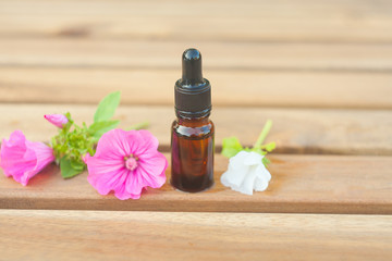 mallow essential oil in  beautiful bottle on wooden background