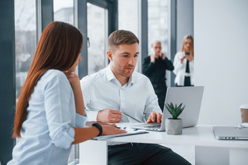 Group of young successful team that working and communicating together indoors in office