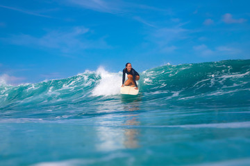 Female surfer on a blue wave