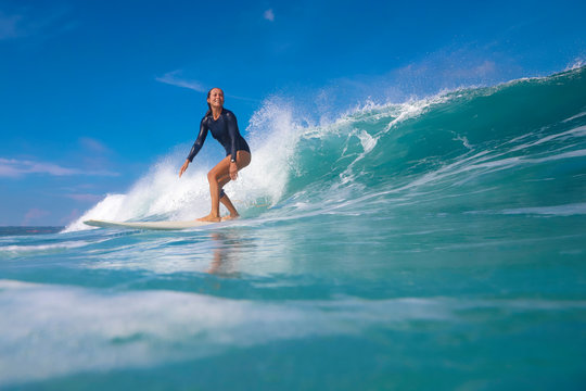 Female surfer on a blue wave